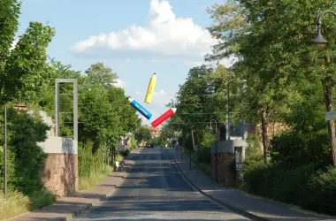 Wilkommensgruß Einfahrt Hünfeld, Stifte mit Aufschrift " Das Offene Buch" schwebend üner der Straße